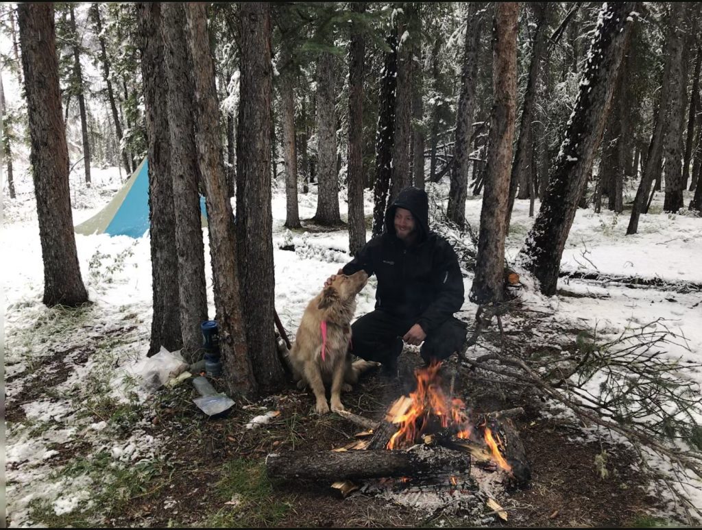 man and cute dog camping snow
